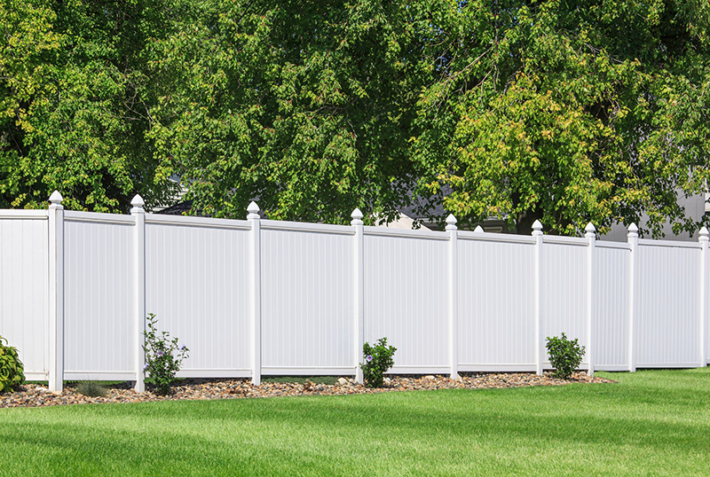 Vinyl Fence-175545195 White vinyl fence around a yard with large trees